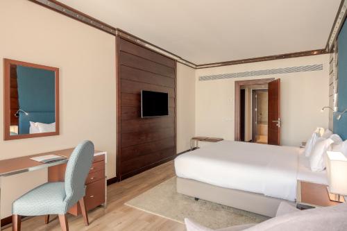 a bedroom with a bed and a desk and a computer at Sesimbra Oceanfront Hotel - Preferred Hotels and Resorts in Sesimbra