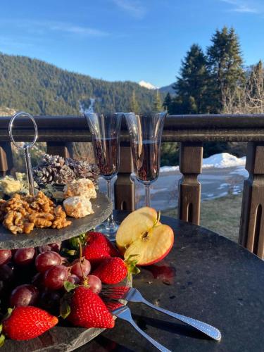 a table with two glasses of wine and strawberries at Ξενοδοχείο ΜΑΓΚΙΩΣΗ in Neraïdochóri