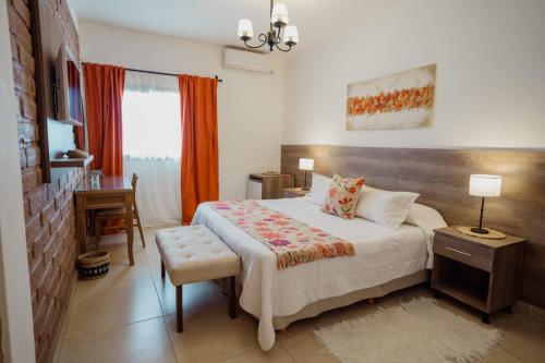 a bedroom with a bed and a table and a chair at Luna de Cafayate Hotel Boutique in Cafayate