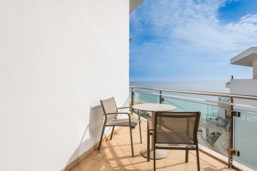 a balcony with two chairs and a table at Sesimbra Oceanfront Hotel - Preferred Hotels and Resorts in Sesimbra