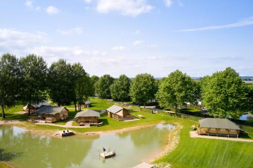 an aerial view of a lake with a group of huts at Safaritenten Betuwe in Kesteren
