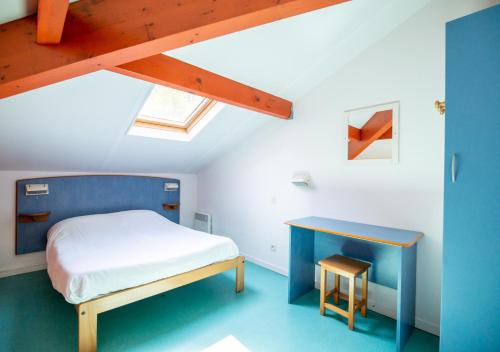 ein kleines Schlafzimmer mit einem Bett und einem Schreibtisch in der Unterkunft Village Vacances Le Lac Marin in Soustons