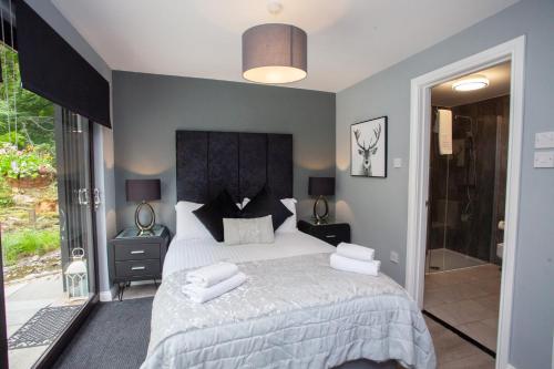 a bedroom with a large bed with two pillows on it at The Ultimate Luss Retreat in Luss