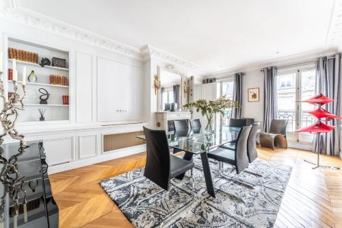 une salle à manger avec une table en verre et des chaises noires dans l'établissement Luxury Living Georges V, à Paris