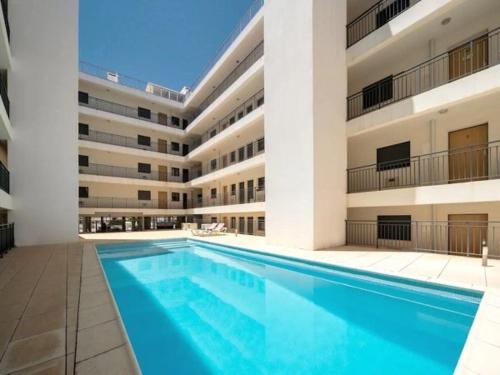 a swimming pool in front of a large building at Sunshine apartment by Ammonite&Cо in Olhão