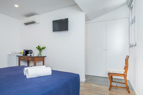 a bedroom with a blue bed and a chair at Casa da Praça Double room - by Casas na Ilha in Funchal