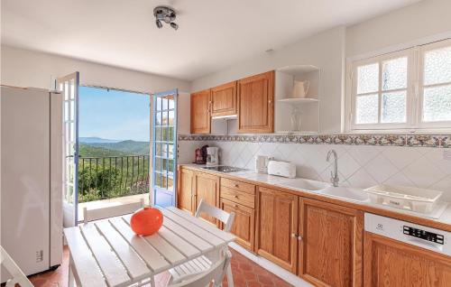a kitchen with wooden cabinets and a large window at Amazing Home In Les Adrets-De-L'estére in Les Adrets de l'Esterel