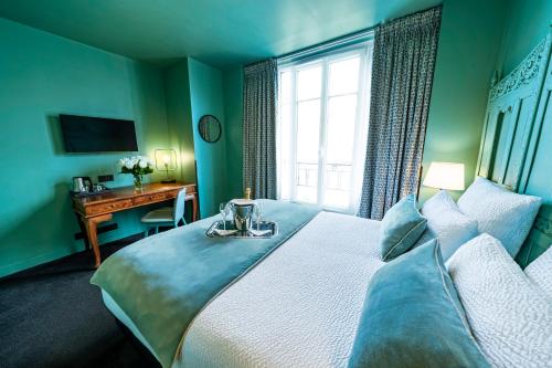 a bedroom with a bed with a desk and a window at Hotel Villa Nicolo - Tour Eiffel in Paris