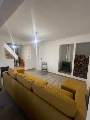 a living room with a yellow couch and a tv at Casa da Barragem Montargil in Montargil