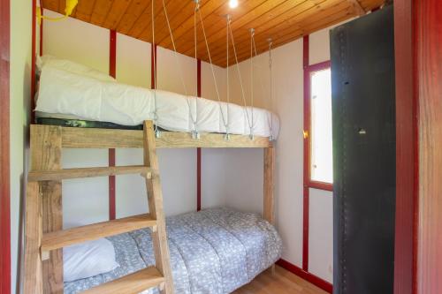 a bunk bed in a room with a ladder at Bungalow Moulin Du Gournier in Malbosc