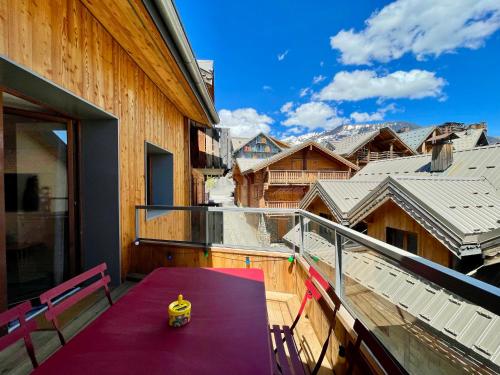 un balcon avec une table et des chaises violettes et une vue dans l'établissement Homency - Résidence Fermes de l'Alpe A302, à L'Alpe-d'Huez
