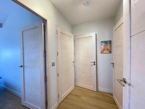 un couloir avec deux portes et un miroir dans l'établissement Homency - Résidence Fermes de l'Alpe A302, à L'Alpe-d'Huez