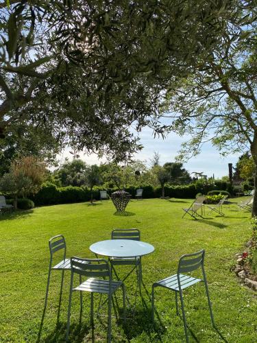 a table and chairs in a park with a table and chairs at Logis Hôtel Château De Palaja in Carcassonne