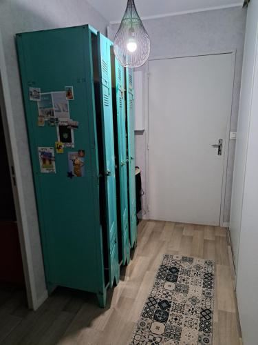 a row of green lockers in a hallway with a door at Petite Chambre CHEZ MARINA in Chantepie
