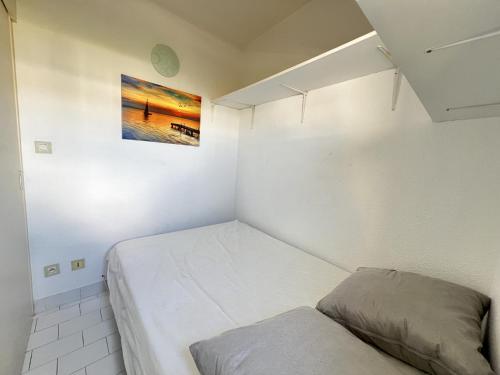 - une petite chambre avec un lit et une photo sur le mur dans l'établissement Sol-y-Days Tropic, P2 avec vue sur jardins, à La Grande Motte