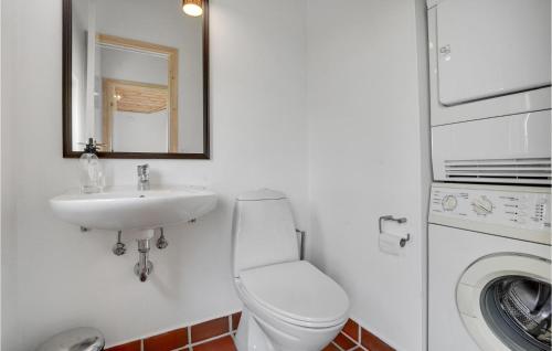 a bathroom with a toilet and a sink and a washing machine at Holiday Home Tingodden Denm I in Hvide Sande
