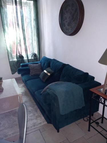 un salon avec un canapé bleu dans une pièce dans l'établissement Cosy 2, à Vias