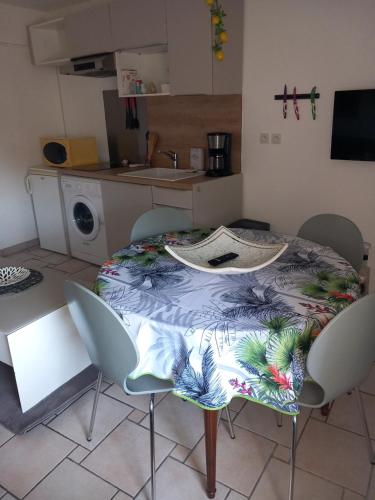 - une table et des chaises dans une cuisine avec une table et une table dans l'établissement Cosy 2, à Vias