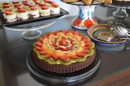 a cake with fruit on it on a table with other desserts at Splendid Hotel Taormina in Taormina