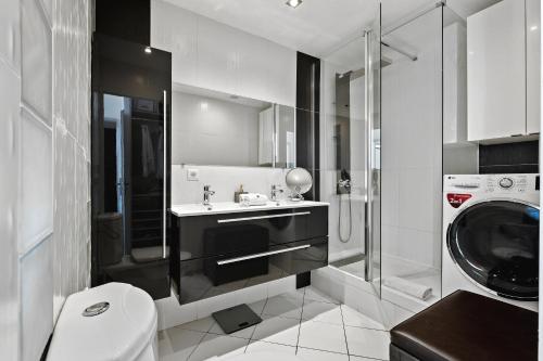 une salle de bain avec un lavabo et une machine à laver dans l'établissement Immogroom - T4 - Center - 8 min from Palais, à Cannes