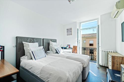 deux lits dans une chambre avec balcon dans l'établissement Immogroom - T4 - Center - 8 min from Palais, à Cannes