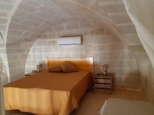 a bedroom with a bed in a stone wall at Villetta in Centro Storico - Chalet in Old Town in Maglie