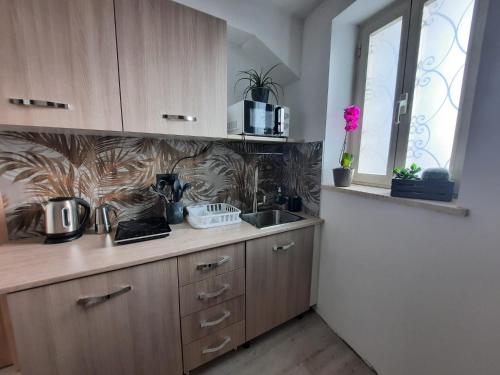 a kitchen with wooden cabinets and a sink and a window at Viccinella House in Capranica