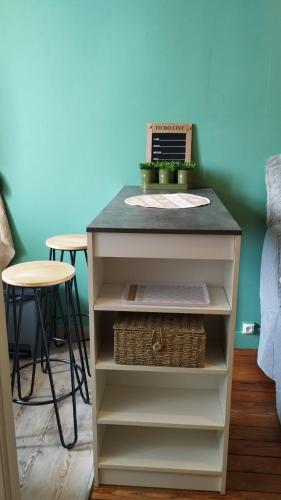 une table avec un ordinateur portable sur une étagère dans l'établissement Le Nid Douillet, à Clamart