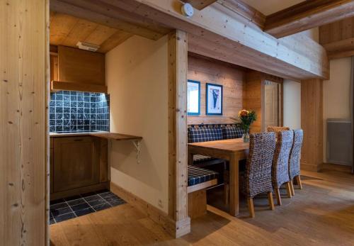 une salle à manger avec une table et des chaises en bois dans l'établissement L'Aquila 34 - 3-bedroom ski-in ski-out apartment, à Val dʼIsère