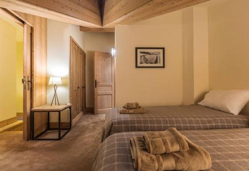 une chambre avec deux lits et une table avec une lampe dans l'établissement L'Aquila 34 - 3-bedroom ski-in ski-out apartment, à Val dʼIsère