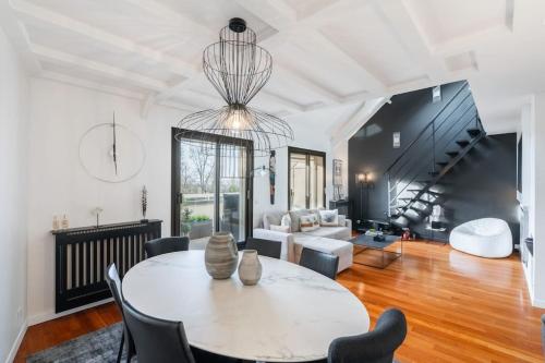 un salon avec une table et des chaises dans l'établissement Sublime loft luxueux avec terrasse, à Saint-Germain-en-Laye