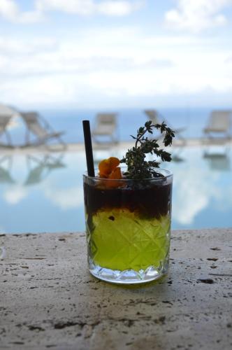 a drink sitting on a table next to the ocean at Splendid Hotel Taormina in Taormina