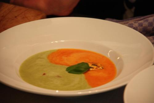 a white bowl of soup with a leaf in it at Gasthof zum Hirsch in Neukirch