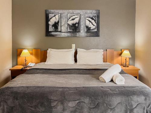 a bedroom with a bed with two towels on it at Pousada Nacional Inn Campos do Jordão in Campos do Jordão