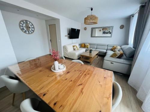 un salon avec une table en bois et un canapé dans l'établissement Paris - Appartement confortable proche Canal Ourcq, à Paris