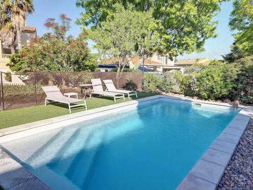une piscine avec deux chaises et une table dans l'établissement Grande villa entièrement rénovée avec piscine, à Pinet