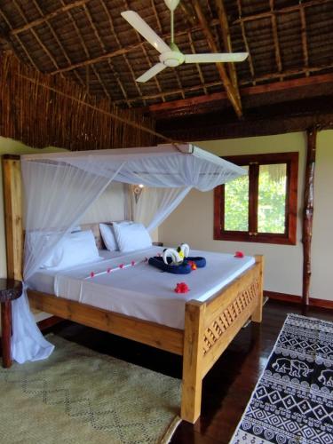 a bedroom with a bed with a mosquito net at MONKEY MOUNTAIN LODGE in Mtende