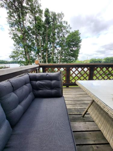 a couch sitting on a wooden deck with a table at Apartament nad jeziorem Zamkowym in Wałcz