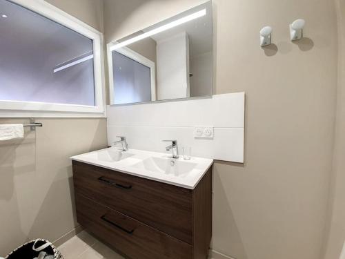 une salle de bain avec un lavabo et un miroir dans l'établissement Grande villa entièrement rénovée avec piscine, à Pinet