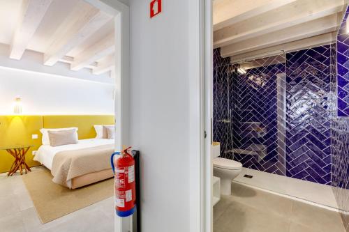 ein Bad mit einem Bett und einem WC in einem Zimmer in der Unterkunft Casinhas da Praia in Vila Praia de Âncora