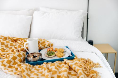 a tray with a plate of food on a bed at Silverbow Inn in Juneau