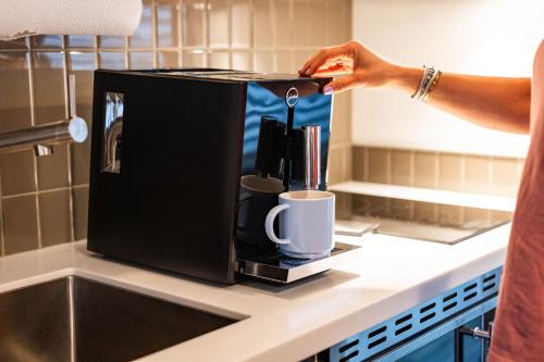 a person is pouring coffee into a coffee maker at Silverbow Inn in Juneau