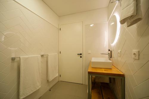 Un baño blanco con lavabo y espejo. en Azimute 5, en Angra do Heroísmo