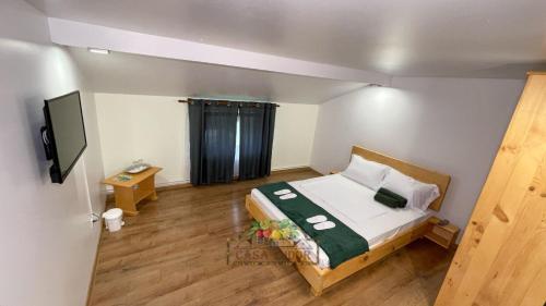 a small room with a bed and a television at Casa Tudor in Tîrgu Ocna