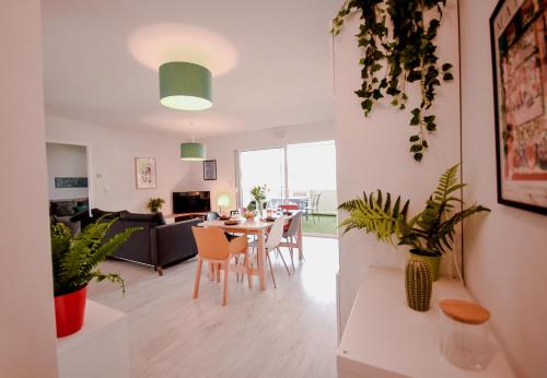 a living room and dining room with a table and chairs at Appartement lumineux proche lac in Mimizan