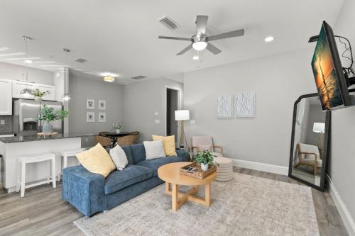a living room with a blue couch and a table at NEW! Canopy Cabana - Luxury Downtown Apartment in Safety Harbor
