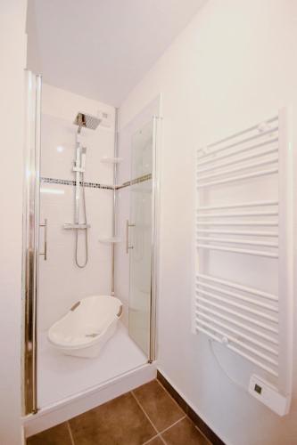 une salle de bain blanche avec douche et toilettes dans l'établissement Appartement lumineux proche lac, à Mimizan