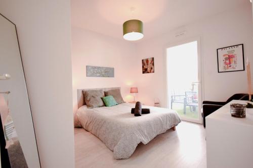 une chambre blanche avec un lit et une fenêtre dans l'établissement Appartement lumineux proche lac, à Mimizan