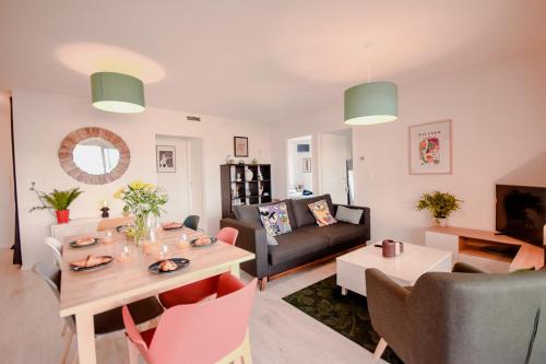 a living room with a table and a couch at Appartement lumineux proche lac in Mimizan