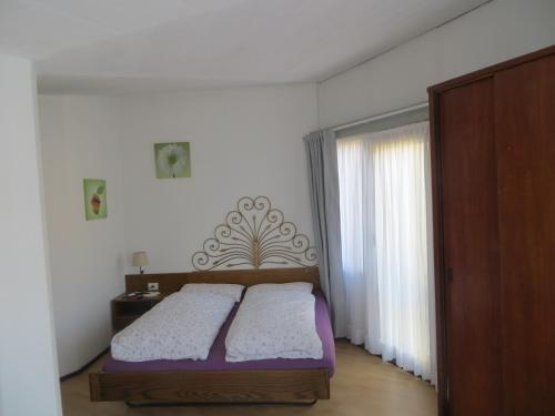 1 dormitorio con cama y ventana en Ristorante Domino, en Agno